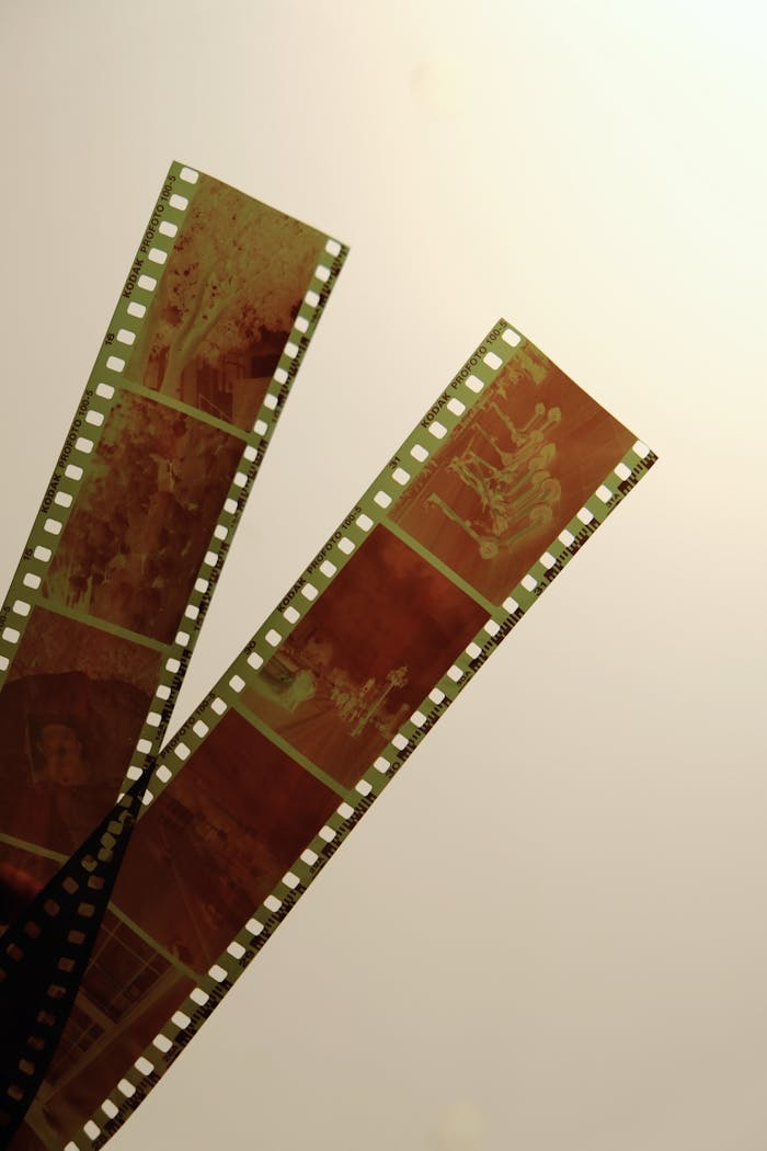 Close-up of vintage negative film strips with a retro feel on a subtle yellow background.